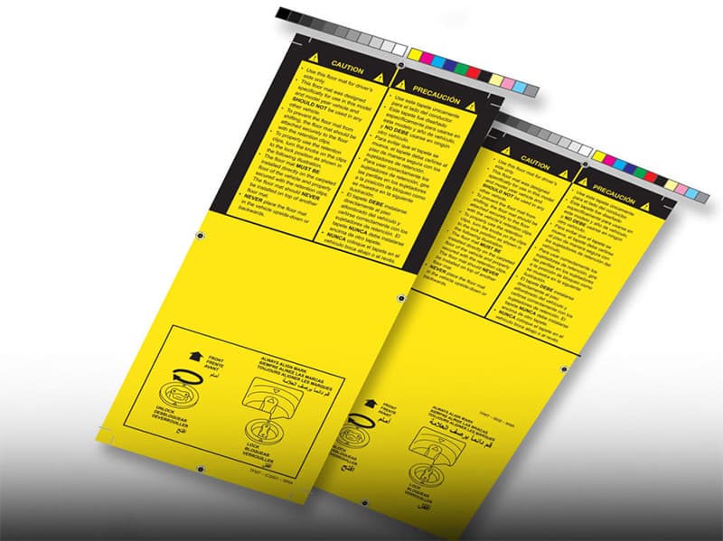 Toyota floor mat caution tags in English and Spanish